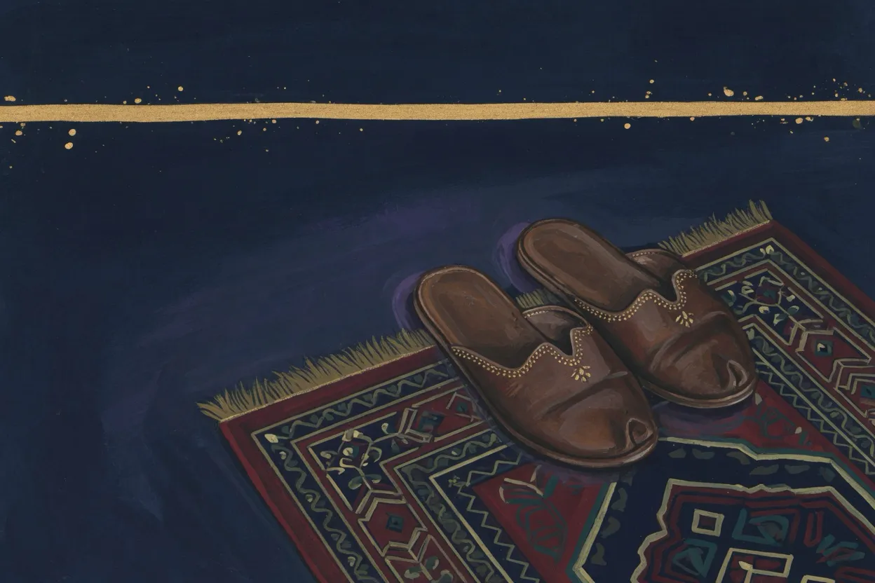 زوج خف جلد بني على حافة سجادة صلاة.